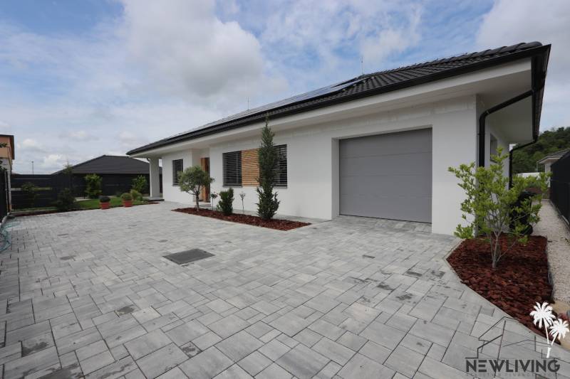 Ein Einfamilienhaus in Piešťany mit Garage, gepflastertem Hof und Grünflächen.