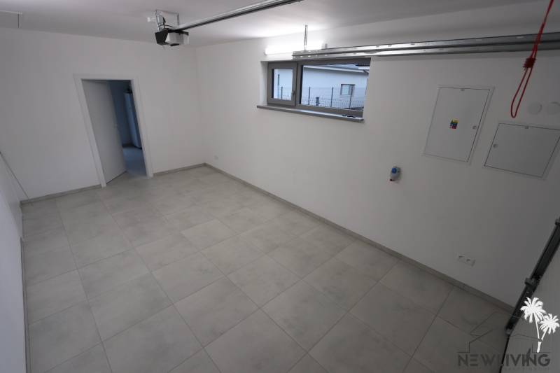 Priestranná miestnosť so svetlými dlaždicami v rodinnom dome.  
Großzügiger Raum mit hellen Fliesen in einem Einfamilienhaus.