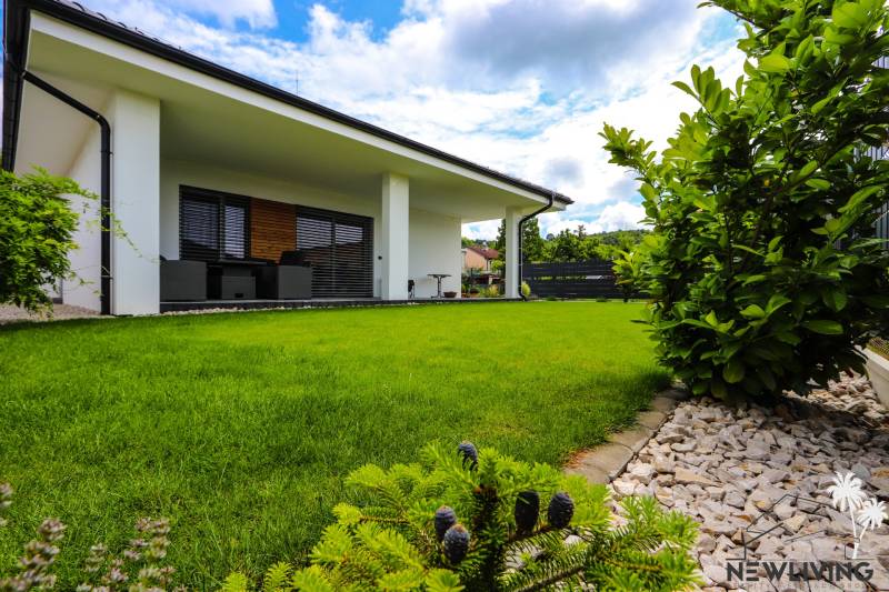 Ein Einfamilienhaus in Piešťany mit grünem Rasen, Terrasse und gepflegtem Garten.