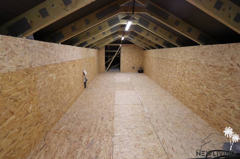 Das Dachgeschoss eines Einfamilienhauses mit Holzpaneelen und sichtbarer Konstruktion.