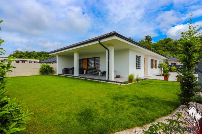 Ein Einfamilienhaus in Piešťany mit einer verglasten Terrasse und einem grünen Rasen.