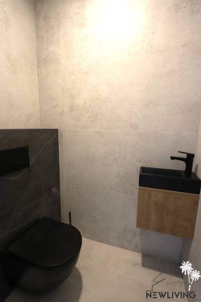 Schwarz-weißes Badezimmer mit einem hängenden Waschtischunterschrank in einem Einfamilienhaus.