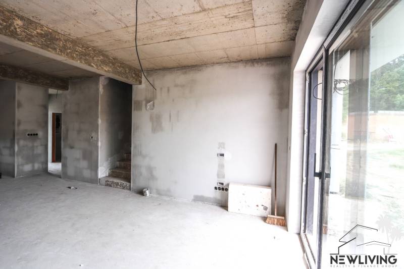 Das Innere eines unvollendeten Einfamilienhauses, Betonwände und Treppen führen in den ersten Stock.