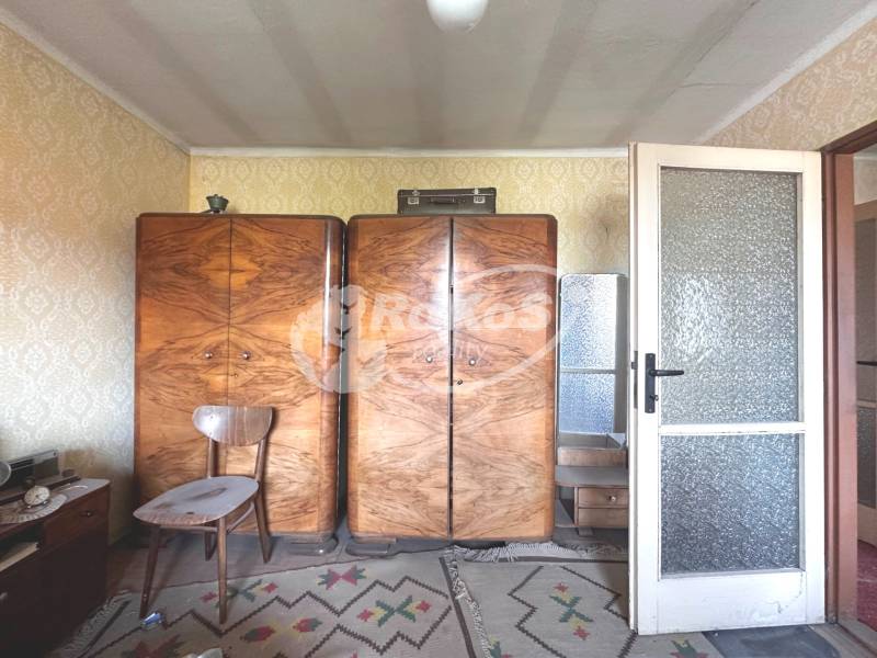 Retro-Möbel mit Holzschränken in einer 3-Zimmer-Wohnung mit Teppichboden und Tapeten.