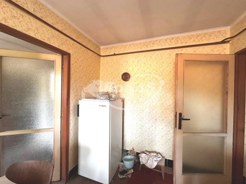 Innenraum einer 3-Zimmer-Wohnung mit Kühlschrank und Türen mit Glaspaneelen.