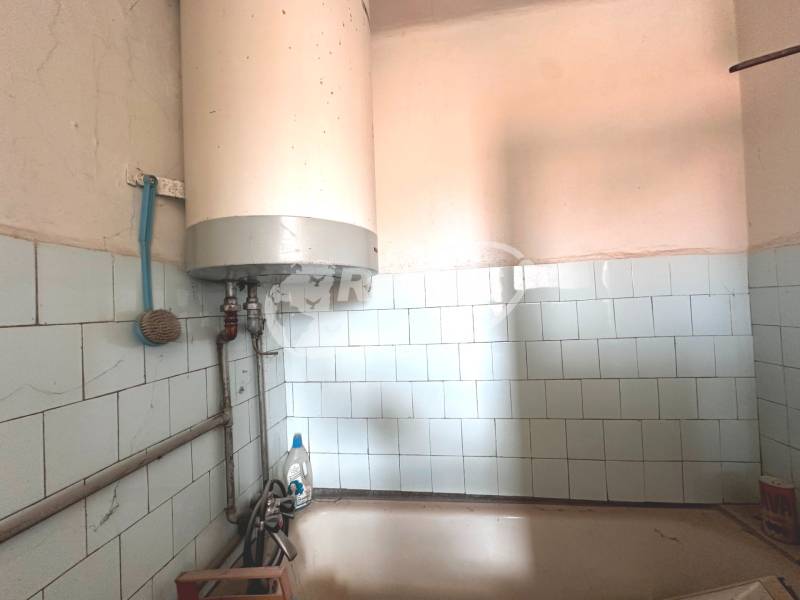 Ein Wandboiler mit weißen Fliesen in einer 3-Zimmer-Wohnung mit Badezimmer.