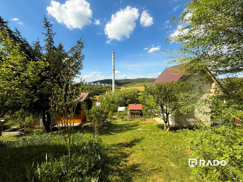 Gärten in Trenčín mit Blick auf den Schornstein, den Himmel und überall umgeben von Grün.