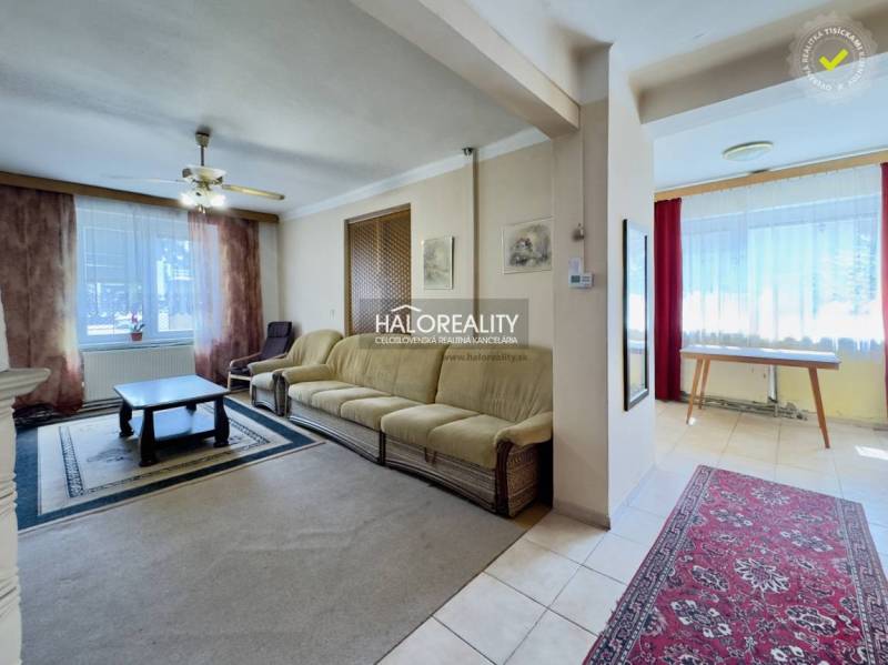 Wohnzimmer in einem Einfamilienhaus mit Sofa, Couchtisch und Teppichen.