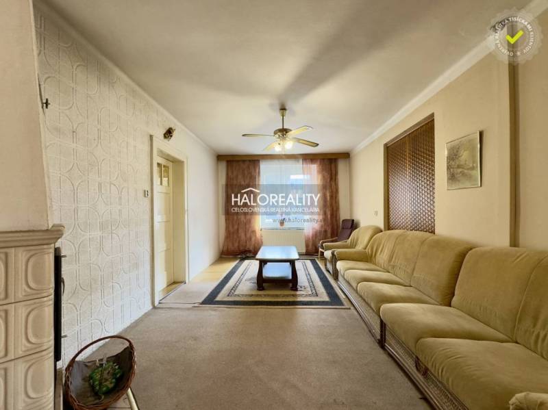 Wohnzimmer mit großem Sofa und Kachelofen in einem Einfamilienhaus.