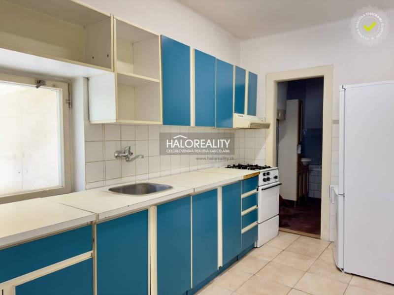 Eine Küche mit blauen Schränken und weißen Geräten in einem Einfamilienhaus.