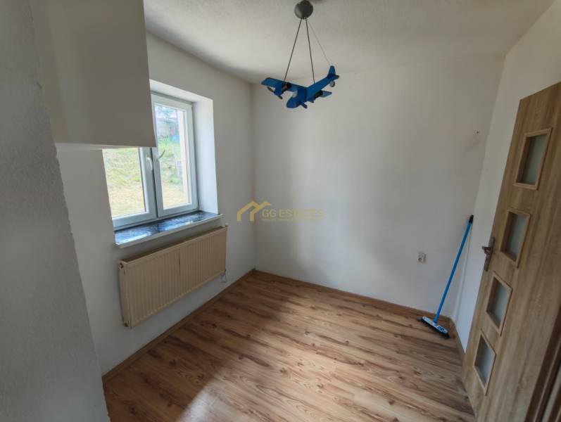 Ein Zimmer mit einem blauen Flugzeug-Luster, Holzboden und Fenster in einem Einfamilienhaus.
