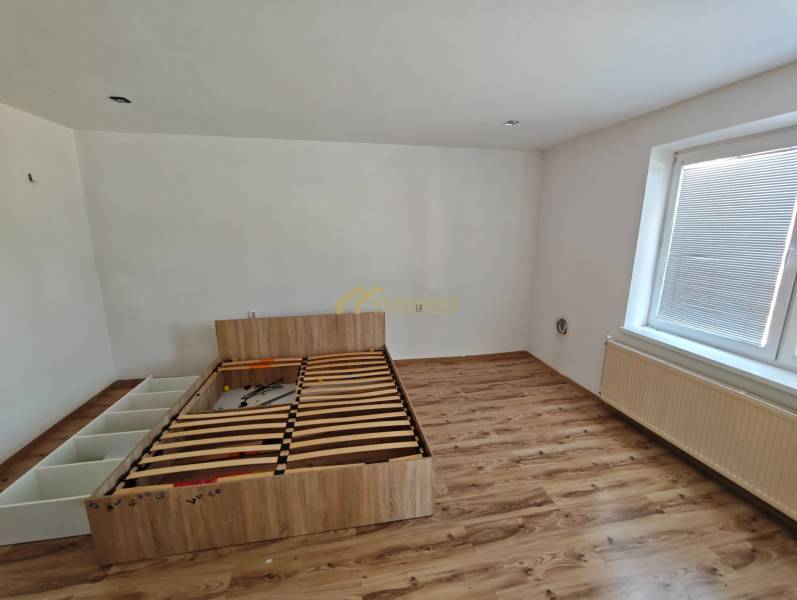 Schlafzimmer mit Bett und Laminatboden in einem Einfamilienhaus.