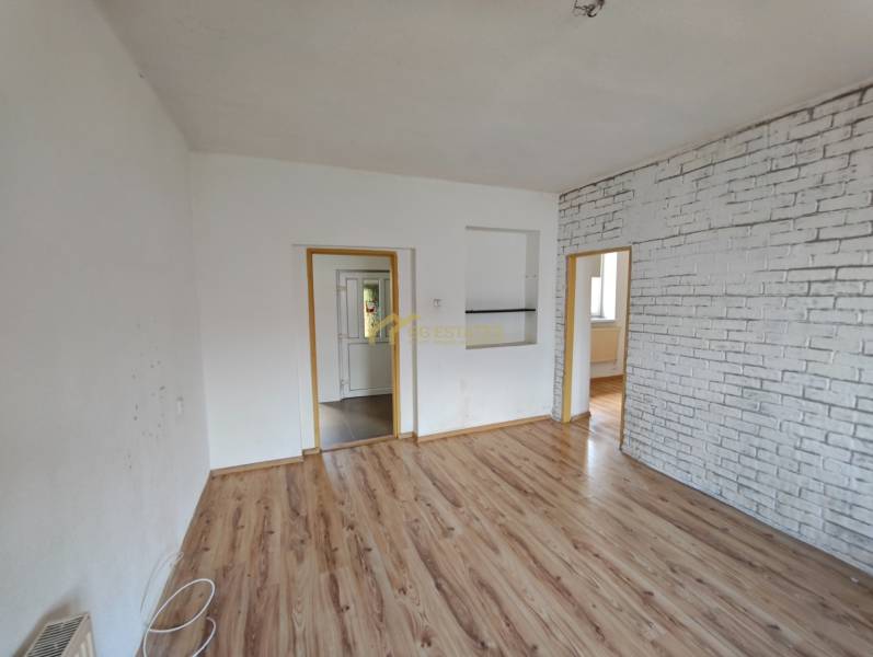 Innenraum eines Einfamilienhauses mit Laminatboden und Ziegeldekor an der Wand.
