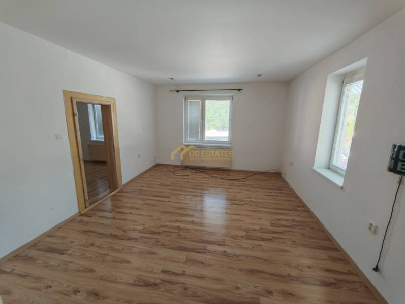 Ein Zimmer in einem Einfamilienhaus mit Holzboden und weißen Wänden.