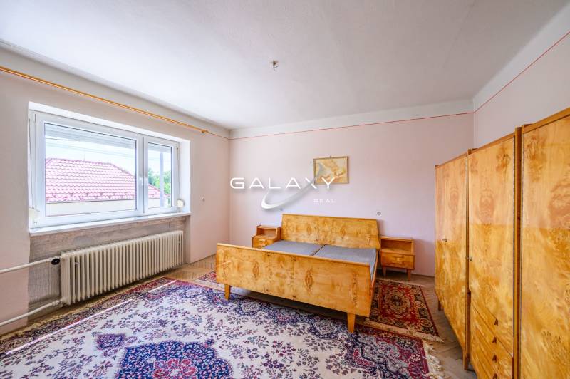 Ein Schlafzimmer im Einfamilienhaus mit antiken Möbeln und Teppich.