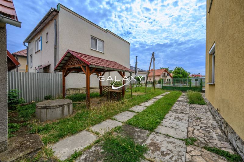 Einfamilienhaus in Vidiná mit Unterstand und Brunnen im gepflegten Garten.