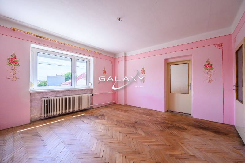 Rosa Wände mit Blumendekoration, Holzboden, großes Fenster in einem Einfamilienhaus.