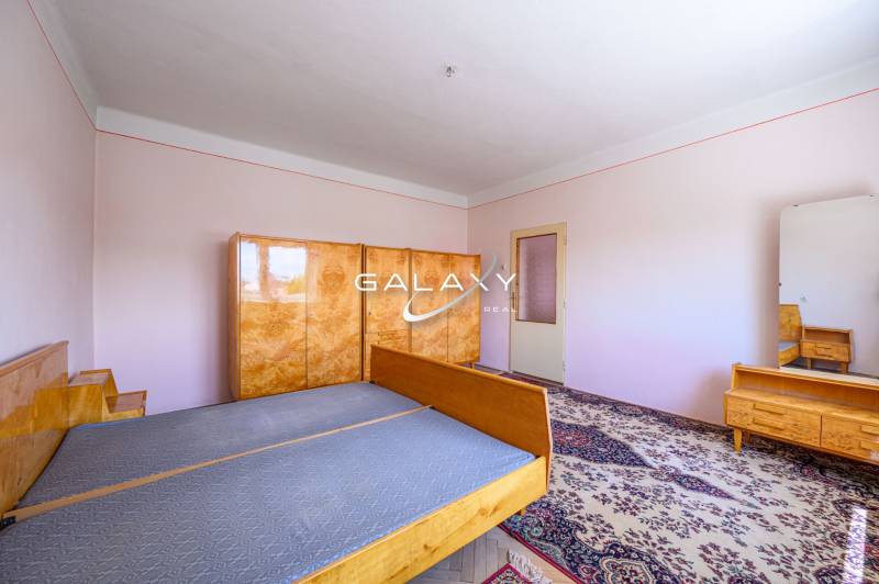 Schlafzimmer in einem Einfamilienhaus mit Holzmöbeln und Teppichboden.