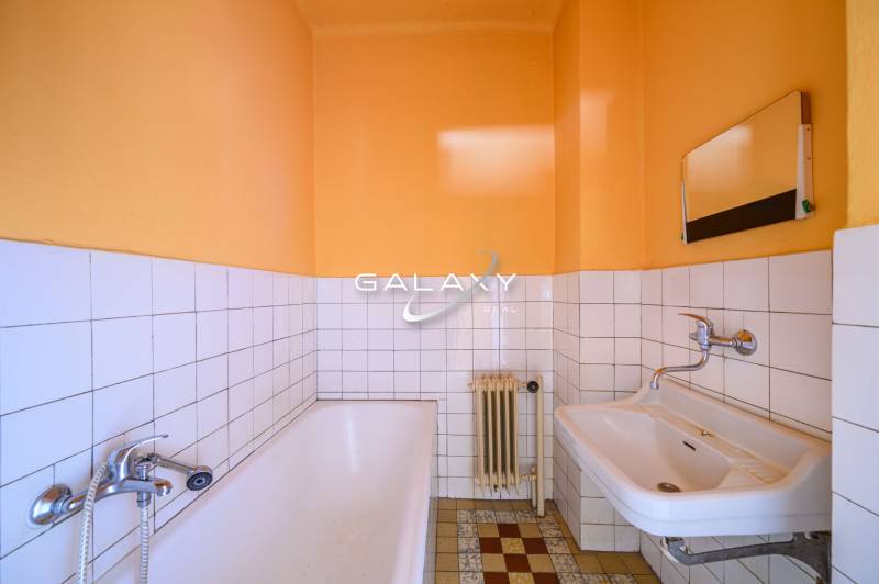 Badezimmer in einem Einfamilienhaus mit Badewanne, Waschbecken und Wandfliesen.