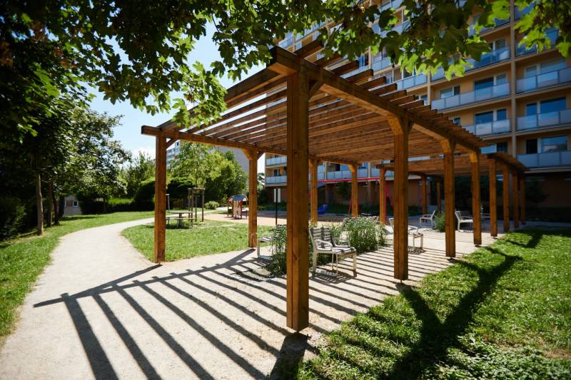 Ein hölzerner Pavillon mit Bänken im Park in Košice, Stadtteil Juh, umgeben von Grün.
