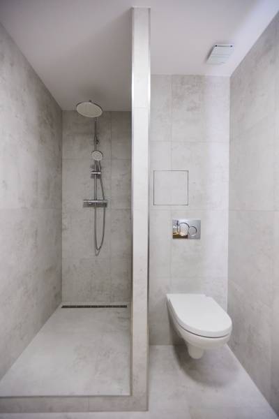 Badezimmer mit Dusche und Toilette, minimalistischer Stil in einer 2-Zimmer-Wohnung.