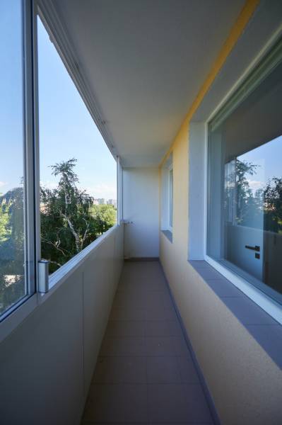 Ein verglaster Balkon in einer 2-Zimmer-Wohnung mit Blick ins Grüne.