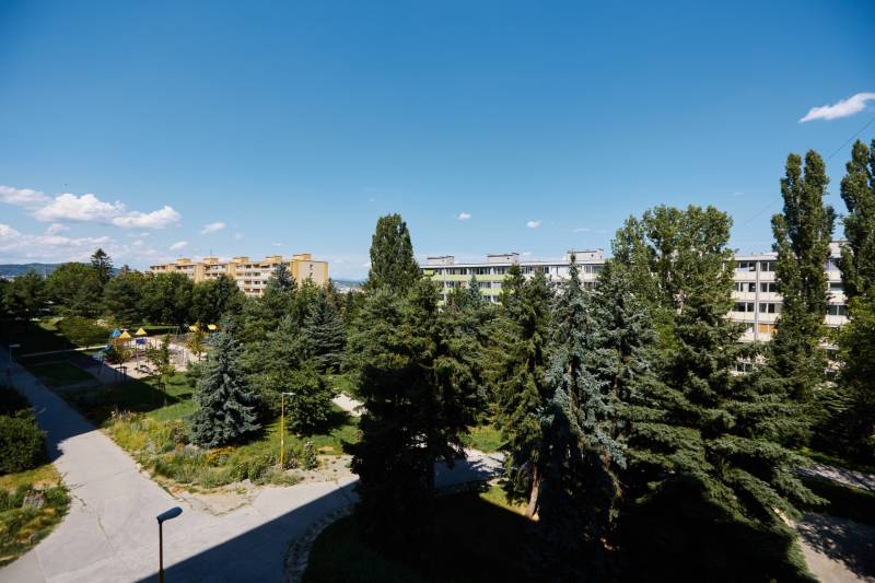 Blick auf Wohngebäude, umgeben von Bäumen und einem Spielplatz in Košice, Stadtteil Juh.