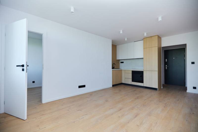 Küche in einer 2-Zimmer-Wohnung mit Holzboden und eingebauten Geräten.