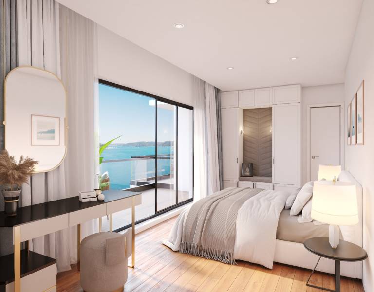 Ein helles Schlafzimmer in einer Villa mit Blick auf das Meer von einem privaten Balkon.