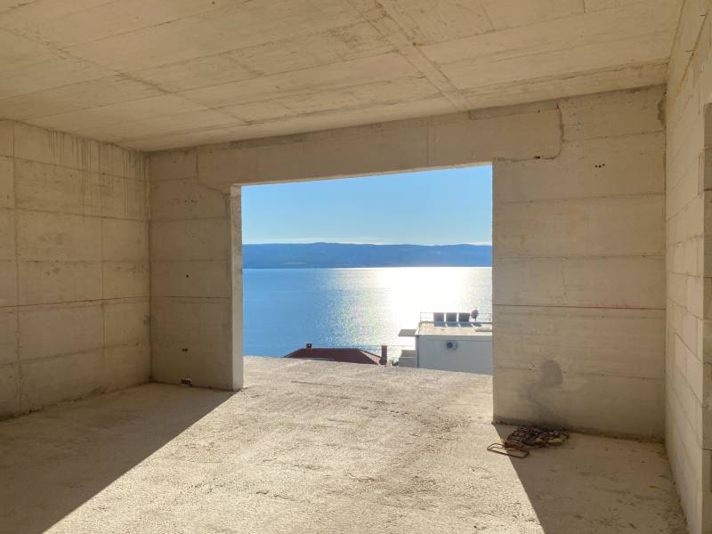 Unvollendetes Interieur einer Villa mit Blick auf das Meer und Sonnenuntergang im Hintergrund.