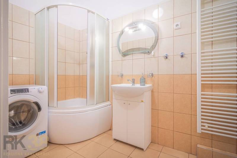 Badezimmer in einer 3-Zimmer-Wohnung mit Dusche, Waschmaschine und Waschbecken.