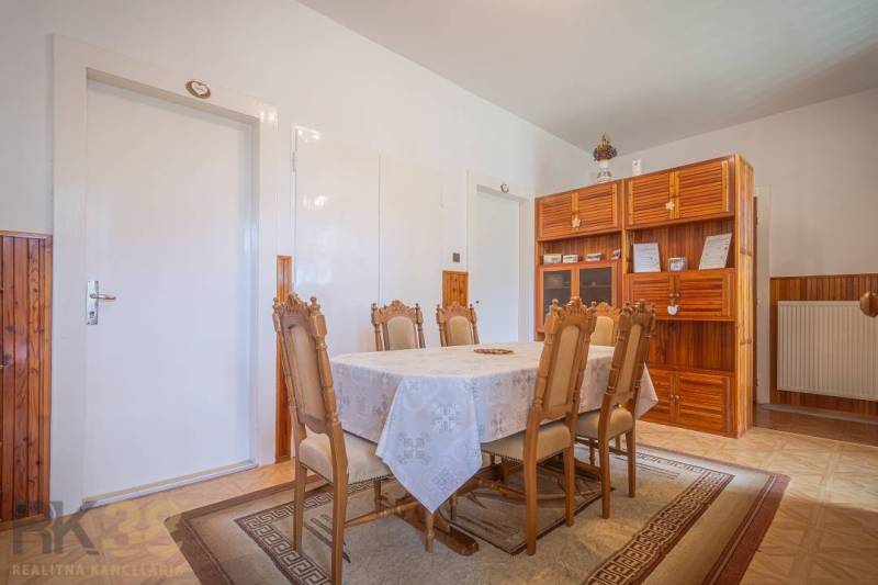 Esszimmer mit Tisch und Stühlen, Holzschrank, Heizkörper, 3-Zimmer-Wohnung.