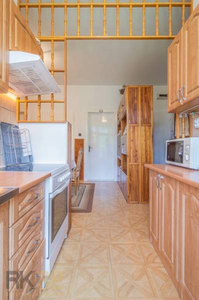 Küche in einer 3-Zimmer-Wohnung mit Herd, Mikrowelle und Holzschränken.