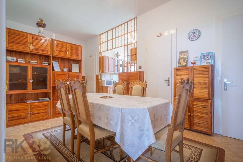 Esszimmer in einer 3-Zimmer-Wohnung mit Holzmöbeln und gedecktem Tisch.