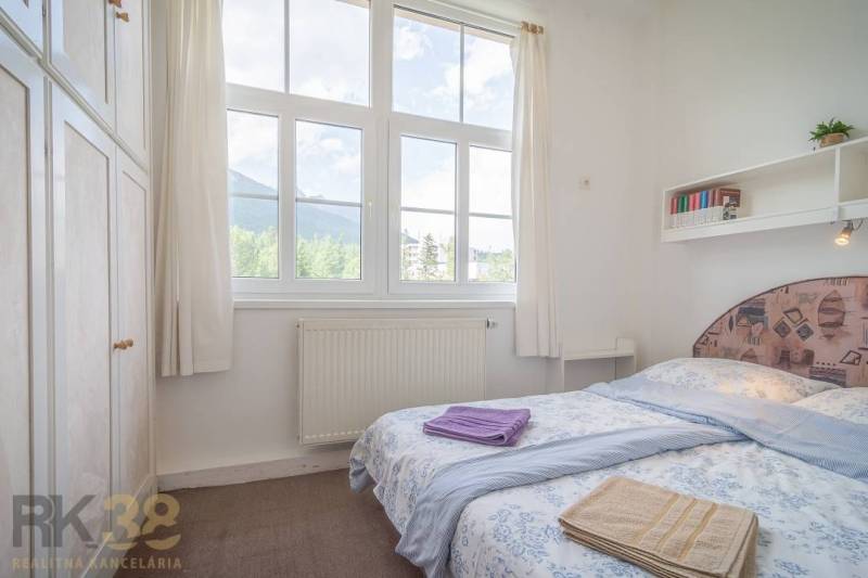 Schlafzimmer in einer 3-Zimmer-Wohnung mit großem Fenster und Blick auf die Berge.