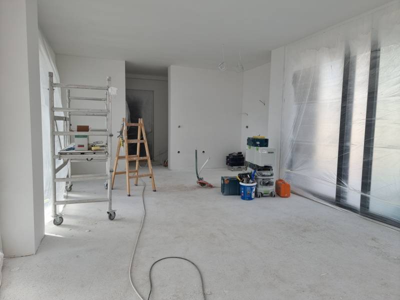 Innenrenovierung in der Villa mit Leiter, Werkzeug und Folie auf dem Boden.