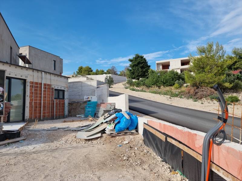 Baufläche bei der Villa in Vodice mit Straße und umliegendem Grün.