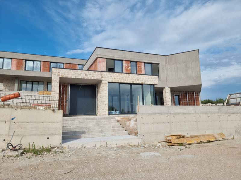 Unvollendete Villa in Vodice mit großen Glasflächen und Steinverkleidung.