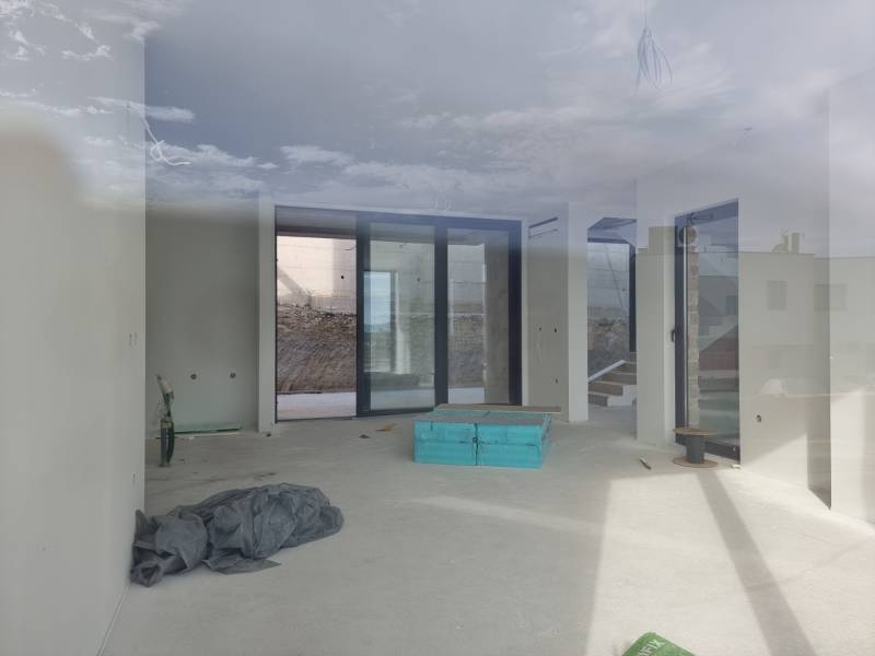 Geräumiges Interieur einer Villa mit großen Fenstern und Blick auf das Äußere.