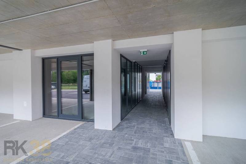 Geschäftsräume in Svit mit Glastüren und gefliestem Boden neben einem Parkplatz.