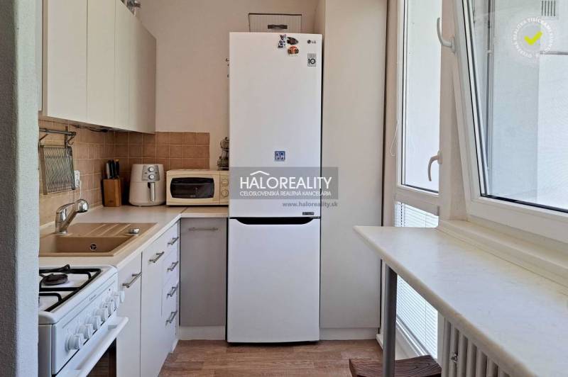 Küche in einer 3-Zimmer-Wohnung mit Kühlschrank, Mikrowelle und Herd.