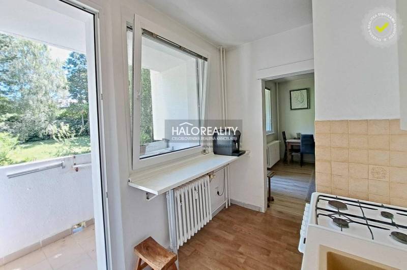 Küche in einer 3-Zimmer-Wohnung mit Blick auf den Balkon und die umliegende Grünfläche.