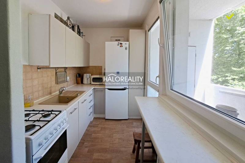 Küche in einer 3-Zimmer-Wohnung mit weißen Schränken, Gasherd und Fenster.