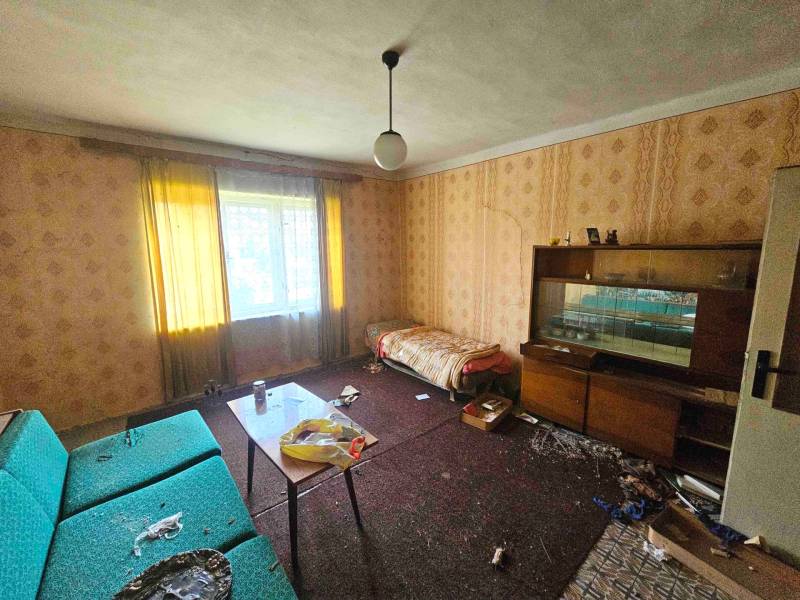 Wohnzimmer in einem Einfamilienhaus mit Sofa, Tapetenwand und Möbeln.
