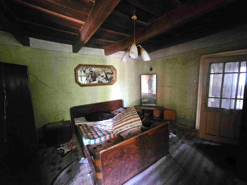 Schlafzimmer in einem Einfamilienhaus mit Holzdecke, Bild und Bett.
