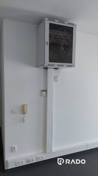 Kanzleien mit Kommunikationsgeräten und Netzwerkschrank an der weißen Wand.