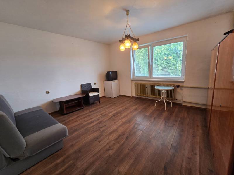 Wohnzimmer in einem Einfamilienhaus mit Holzboden, Sofa und Fenster.