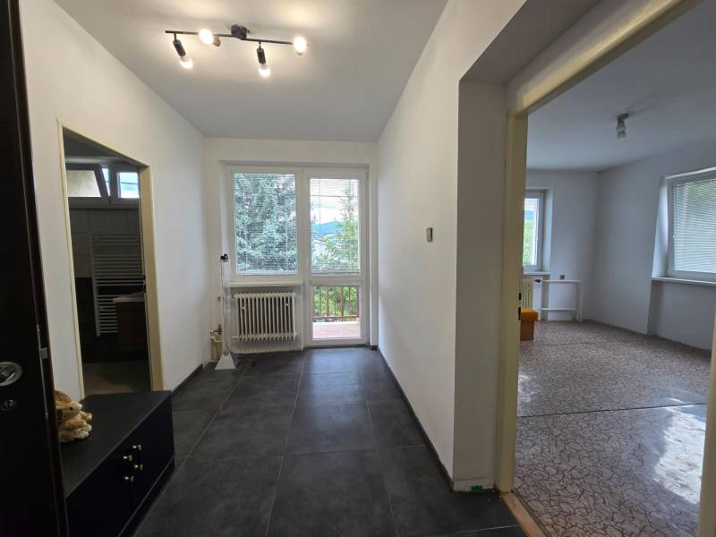 Ein Flur mit Fliesenboden führt zu den Räumen im Einfamilienhaus.