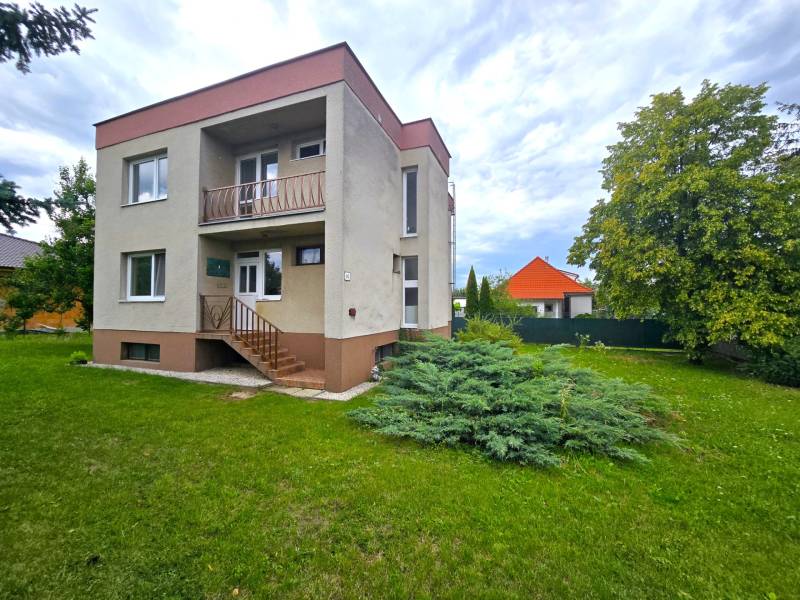 Ein zweistöckiges Einfamilienhaus in Nové Mesto nad Váhom mit Rasen und Baum.