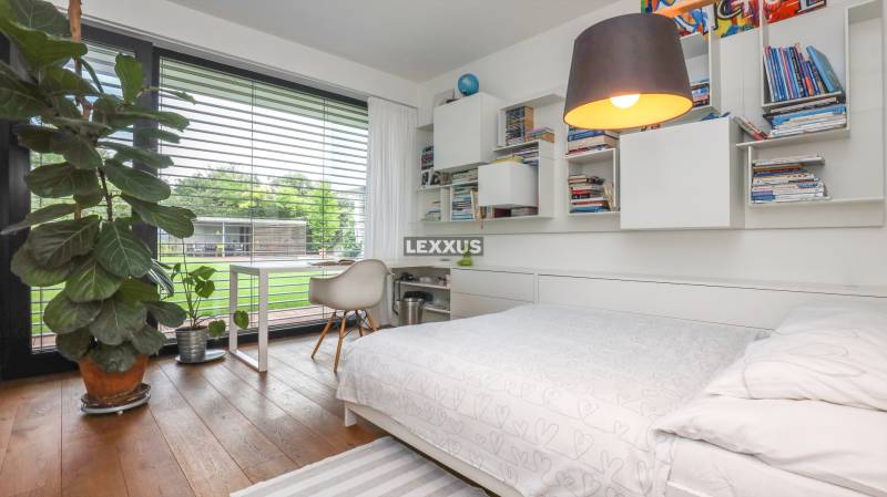 Schlafzimmer in einem Einfamilienhaus mit Bett, Regalen und einem großen Fenster mit Aussicht.